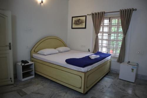 a bedroom with a bed in a room with a window at SWET APARAJITA in Bolpur