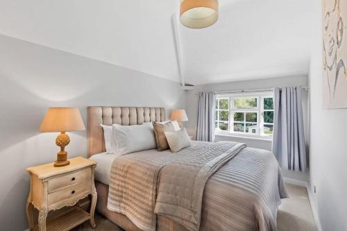 a bedroom with a bed and a table with a lamp at Rosemary Cottage in Leicester