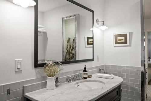 a bathroom with a sink and a mirror at Tribeca Loft Vanderbilt by RoveTravel in New York