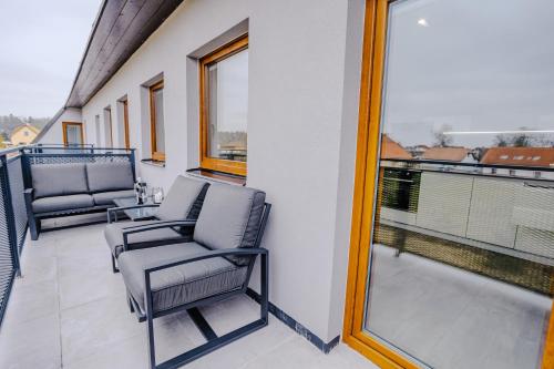 a balcony with two chairs and a large window at Rezidence Petra Voka in Třeboň