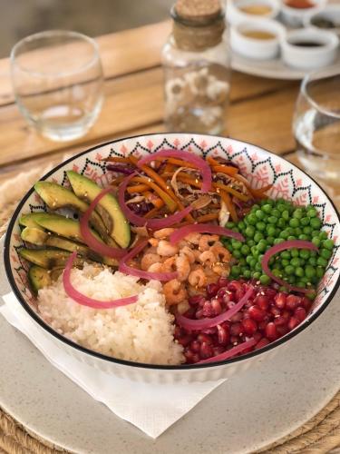 a plate of food with rice and vegetables on a table at Kawga Hôtel in Ngaring