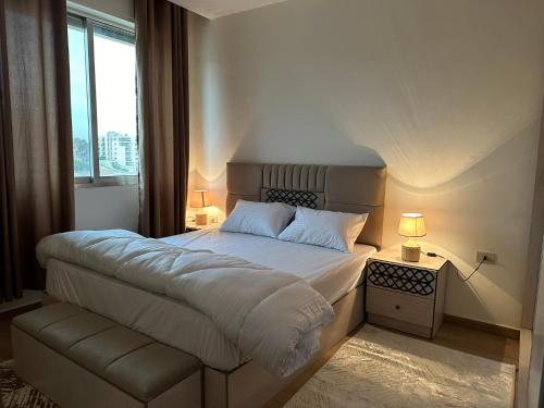 a bedroom with a large bed and a window at Luxury Abdoun apartment in Amman