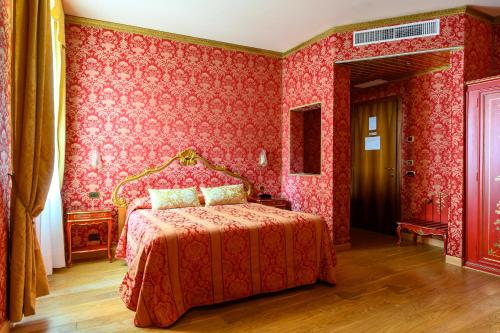 ein rotes Schlafzimmer mit einem Bett und roten Tapeten in der Unterkunft Residenza Ca' San Marco in Venedig