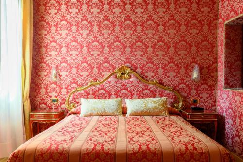 a bedroom with a bed with a red wall at Residenza Ca' San Marco in Venice