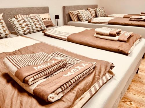 a group of three beds with blankets on them at Cologne LUXE Living: Opulent Elegance Unleashed in Cologne