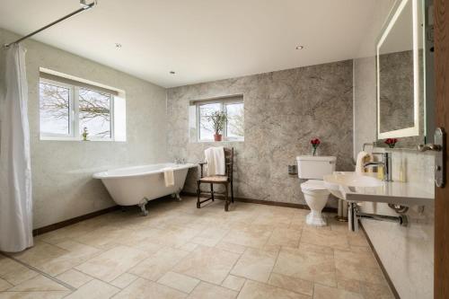 y baño con bañera, aseo y lavamanos. en Pendennis at Eaton Manor, en Church Stretton
