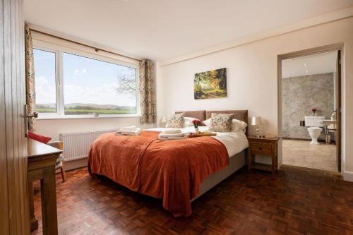 1 dormitorio con cama y ventana grande en Pendennis at Eaton Manor, en Church Stretton
