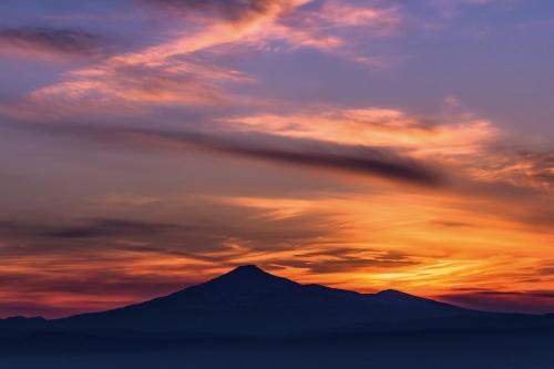 un coucher de soleil avec une montagne en arrière-plan dans l'établissement Hotel Plaza Annex Yokote, à Yokote