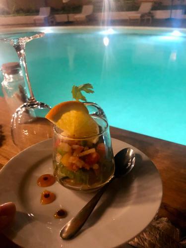 a bowl of food on a plate next to a swimming pool at Kawga Hôtel in Ngaring