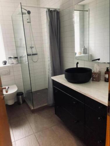 a bathroom with a black sink and a shower at G10 Apartments in Akureyri