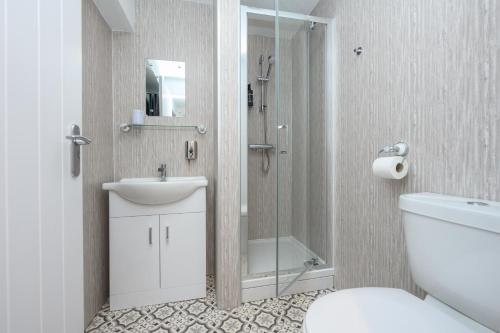 La salle de bains est pourvue d'une douche, d'un lavabo et de toilettes. dans l'établissement Old Town Loft, à Cupar
