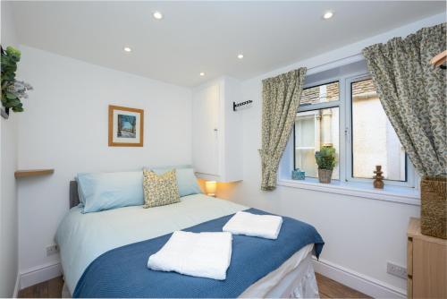 a bedroom with a bed with two towels on it at Old Town Loft in Cupar