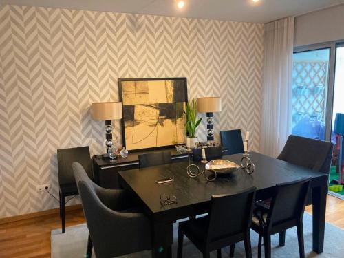 a dining room with a black table and chairs at Oliveira House in Ponta Delgada
