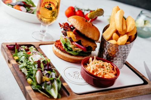 a tray with a sandwich and french fries and a glass of wine at Ingliston Country Club Hotel in Bishopton