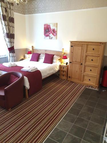 a bedroom with a large bed and a dresser at Appletorre House Holiday Flats - Pet Friendly by arrangement and Private Parking in Torquay