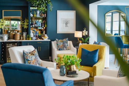 a living room with blue walls and yellow chairs at Last Word Franschhoek in Franschhoek