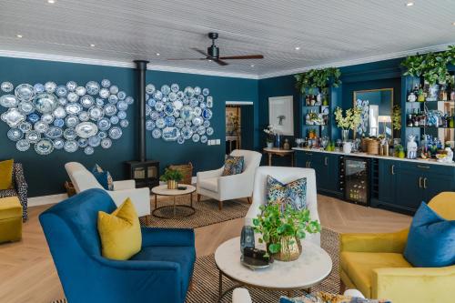 a living room with blue walls and white chairs at Last Word Franschhoek in Franschhoek