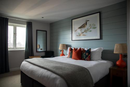 a bedroom with a large bed with blue walls at The Bridge Hotel in Chertsey