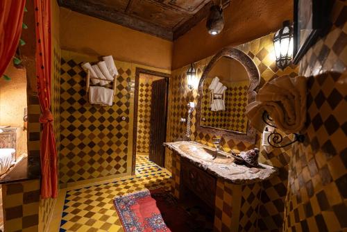 a bathroom with a sink and a mirror at Kasbah Hotel Xaluca Arfoud in Erfoud