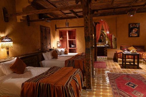 a bedroom with three beds in a room at Kasbah Hotel Xaluca Arfoud in Erfoud