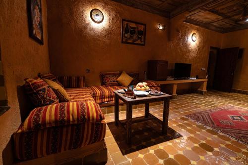 a living room with a couch and a table at Kasbah Hotel Xaluca Arfoud in Erfoud