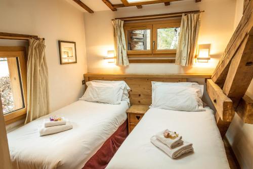 two twin beds in a room with two windows at Chalet Grand Cru in Chamonix-Mont-Blanc
