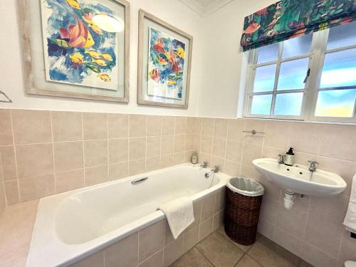a bathroom with a bath tub and a sink at Lloyd Road Cottage in Hallack Rock