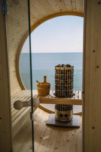 a round window in a room with a view of the ocean at Akrotiri Olympus Luxury Suites - Adults Only in Plaka Litochorou
