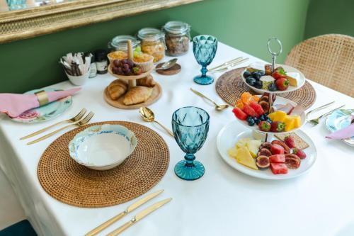 a table with plates of food and bowls of fruit at Last Word Franschhoek in Franschhoek