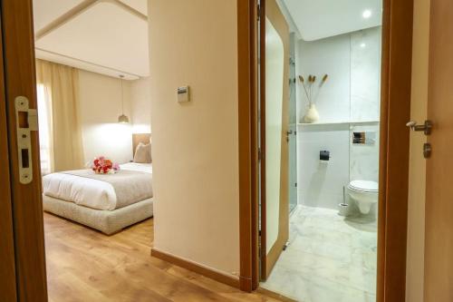 a bedroom with a bed and a bathroom with a toilet at Escapade a Marrakech in Marrakesh