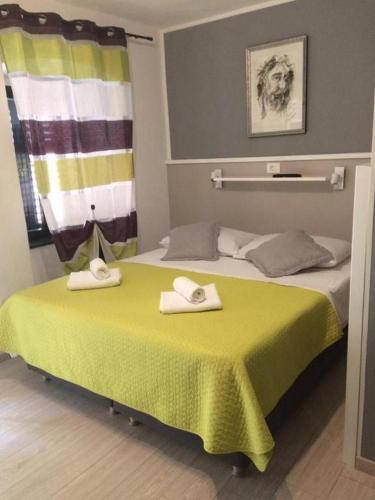 a hotel room with two towels on a bed at Apartments and Rooms Villa Marija in Skradin