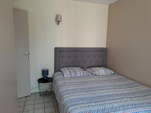 ein Bett mit blauer Decke in einem Schlafzimmer in der Unterkunft maison de plain-pied in Villeneuve-sur-Yonne