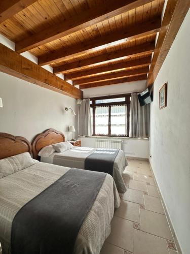 a bedroom with two beds and a window at Casa Rural El Torrejon in Arenas de Cabrales