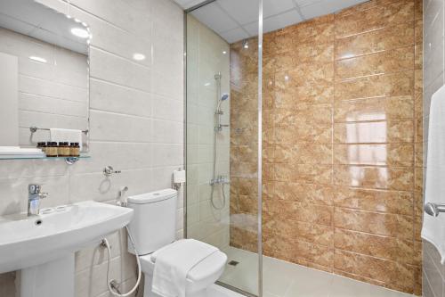 y baño con ducha, aseo y lavamanos. en Silkhaus Elegant Studio Near Silicon Central Mall en Dubái