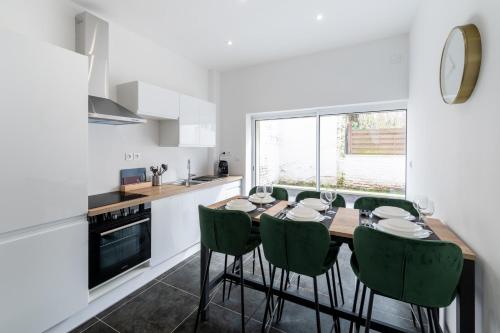 une cuisine avec une table à manger et des chaises vertes dans l'établissement Maison Rivero - Welkeys, à Haubourdin