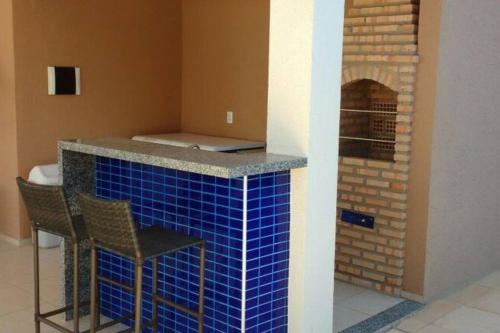 a kitchen with a blue tiled counter with two chairs at Apartamento Confortável. Auxílio/dicas na cidade. in Juazeiro do Norte