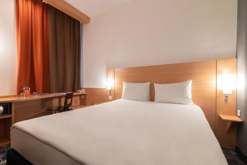 a bedroom with a large white bed in a hotel at Ibis Astana in Astana