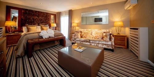 a large bedroom with a bed and a couch at Ingliston Country Club Hotel in Bishopton