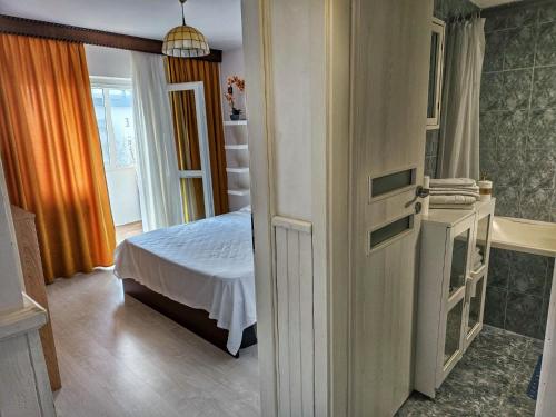 a bedroom with a bed and a bathroom with a tub at Premium White house in Bucharest