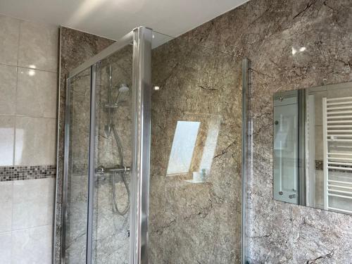 a shower with a glass door in a bathroom at The Townhouse in Fort William