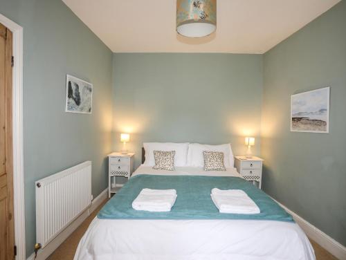 a bedroom with a large bed with two night stands at Amelie Cottage in Beaumaris