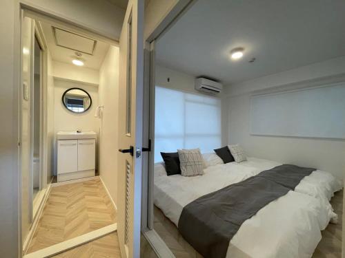 Cette petite chambre comprend un grand lit. dans l'établissement bHOTEL Dai3Himawari - Up to 10p 1 min Peace Park, Wonderful huge house, à Hiroshima