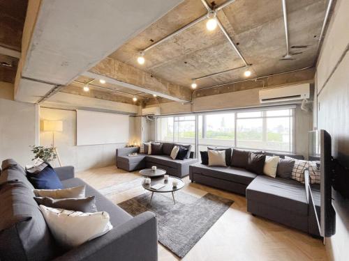 a living room with a couch and a table at b hotel Dai3Himawari - Up to 10p 1 min Peace Park, Wonderful huge house in Hiroshima