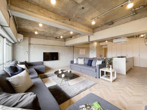 a living room with a couch and a table at b hotel Dai3Himawari - Up to 10p 1 min Peace Park, Wonderful huge house in Hiroshima