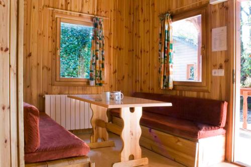 una mesa y un banco en una habitación de madera en Càmping Els Roures en Camprodon
