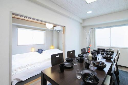 a dining room with a table and a bed at Ishiki - Best location 2 min HiroshimJR station, Up to 10 ppl in Hiroshima