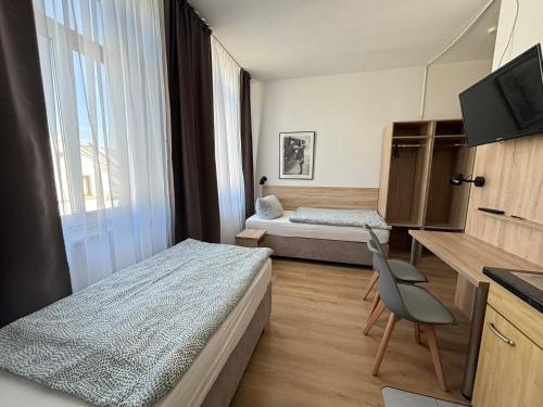 a hotel room with two beds and a television at Deutscher Hof in Plauen