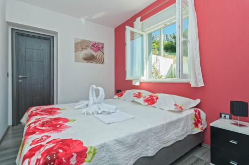 um quarto com uma cama com paredes vermelhas e uma janela em SALONA HILLS with magical view of SPLIT em Solin