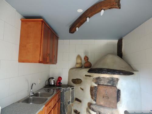a kitchen with an old oven in the corner at Casa do Forno FR in Mondim de Basto