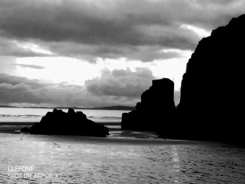 een zwart-witte foto van een strand met rotsen bij North Wales family homes, zip world, Snowdonia, beach retreats in Blaenau-Ffestiniog